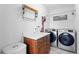 Modern laundry room with front-loading washer and dryer, custom cabinets, and stylish décor at 4589 Quandary Peak St, Brighton, CO 80601