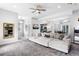 Spacious living room featuring plush seating, neutral tones, and access to kitchen and dining areas at 4589 Quandary Peak St, Brighton, CO 80601