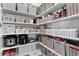 Organized pantry with white shelving, filled baskets, and convenient storage solutions at 4589 Quandary Peak St, Brighton, CO 80601