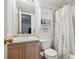 Cozy bathroom featuring a neutral vanity, medicine cabinet, and a toilet next to the tub with a floral shower curtain at 1629 S Deframe St # B8, Lakewood, CO 80228