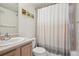 Bright bathroom with a framed pictures, light wood cabinets, toilet and shower with patterned curtain at 1629 S Deframe St # B8, Lakewood, CO 80228