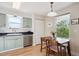 Charming kitchen with light green cabinets, stainless steel dishwasher, and dining table with chairs at 1629 S Deframe St # B8, Lakewood, CO 80228