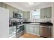 Updated kitchen with stainless steel appliances and light green cabinets at 1629 S Deframe St # B8, Lakewood, CO 80228