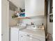 Functional laundry area with side-by-side washer and dryer, and storage shelves at 1629 S Deframe St # B8, Lakewood, CO 80228