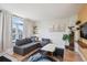 Bright living room featuring a comfortable gray sofa, large arched window, and stylish decor at 1629 S Deframe St # B8, Lakewood, CO 80228