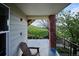 Covered patio with wood chair that offers a private outdoor space with views of lush greenery at 1629 S Deframe St # B8, Lakewood, CO 80228
