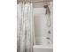 Bright shower stall featuring white tile, rainfall shower head and neutral patterned curtain at 1629 S Deframe St # B8, Lakewood, CO 80228