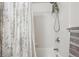 Clean shower stall featuring white tile, a rainfall shower head and a stylish curtain at 1629 S Deframe St # B8, Lakewood, CO 80228
