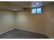 Finished basement room with neutral carpet, recessed lighting, and a window at 15703 E 13Th Pl, Aurora, CO 80011