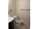 Bathroom displaying toilet and sink with dark wood cabinet at 15703 E 13Th Pl, Aurora, CO 80011