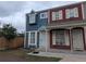 Two-story townhouse featuring blue and red siding, white trim, and a small front lawn at 15703 E 13Th Pl, Aurora, CO 80011