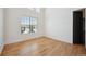 Bright, empty bedroom with hardwood floors, a large window with backyard view, and white walls at 6425 Tremolite Dr, Castle Rock, CO 80108