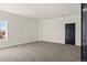 Bright bedroom featuring soft carpet, a window with exterior views, and a modern black door at 6425 Tremolite Dr, Castle Rock, CO 80108