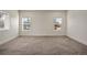 Spacious bedroom with neutral carpet, white walls, and two large windows bringing in natural light at 6425 Tremolite Dr, Castle Rock, CO 80108