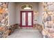 Elegant entrance with double doors, stone accents, and stylish overhead lighting at 6425 Tremolite Dr, Castle Rock, CO 80108
