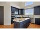 Kitchen featuring an island, stainless appliances, custom cabinets and light countertops at 6425 Tremolite Dr, Castle Rock, CO 80108