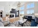 Bright living room featuring high ceilings, modern lighting, and a cozy fireplace at 6425 Tremolite Dr, Castle Rock, CO 80108