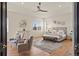 Bright main bedroom with tray ceilings, ceiling fan, and sitting area at 6425 Tremolite Dr, Castle Rock, CO 80108