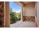 Covered patio with stone accents offers a view of the tree-lined neighborhood at 6425 Tremolite Dr, Castle Rock, CO 80108