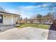 A spacious backyard features a concrete patio and well-maintained lawn with mature trees at 1240 S Chase Ct, Lakewood, CO 80232