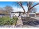 Charming home exterior featuring a well-manicured lawn, mature trees, and a detached garage at 1240 S Chase Ct, Lakewood, CO 80232