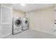 A functional laundry room is equipped with modern appliances and ample storage, featuring tiled floors at 1240 S Chase Ct, Lakewood, CO 80232