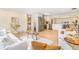 A wide view of a modern living room and kitchen area, with light hardwood floors and bright natural light at 1240 S Chase Ct, Lakewood, CO 80232