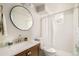 Modern bathroom with sleek vanity, round mirror, and bright white shower at 5885 S Huron St, Littleton, CO 80120