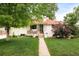 Charming, white-painted home with a red roof, covered porch and meticulous landscaping at 5885 S Huron St, Littleton, CO 80120