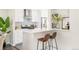 A modern kitchen with white cabinets, a breakfast bar with seating for two, and stainless steel appliances at 5885 S Huron St, Littleton, CO 80120