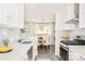 Open kitchen with white cabinets, stainless steel appliances, and view into the dining area at 5885 S Huron St, Littleton, CO 80120