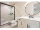 Modern basement bathroom with frameless shower and round mirror at 5820 Powell Rd, Parker, CO 80134