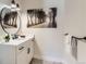 Powder room with floating vanity, round mirror, and black accents at 5820 Powell Rd, Parker, CO 80134