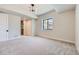 Spacious bedroom with neutral carpet, a walk-in closet, and a modern light fixture at 5820 Powell Rd, Parker, CO 80134