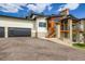 Contemporary home featuring a black garage door, stone accents, and inviting staircase to the front entrance at 5820 Powell Rd, Parker, CO 80134
