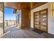 Modern front entrance with double wood doors and a deck overlooking the mountains at 5820 Powell Rd, Parker, CO 80134