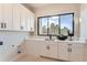 Bright laundry room with white cabinets and a large window at 5820 Powell Rd, Parker, CO 80134