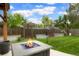 Backyard featuring a stone firepit and well maintained lawn with gardening boxes in background at 4994 S Independence Way, Littleton, CO 80123