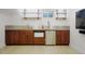 Basement kitchenette featuring stainless steel appliances, a sink, and wood cabinets at 4994 S Independence Way, Littleton, CO 80123