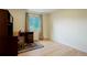 Bedroom with neutral walls, wood floor, bright window, and a dark desk and chair at 4994 S Independence Way, Littleton, CO 80123