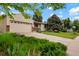 Landscaped front yard with mature trees and a driveway leading to the attached garage at 4994 S Independence Way, Littleton, CO 80123