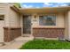 Close-up of the front door with brick accents and well maintained greenery at 4994 S Independence Way, Littleton, CO 80123