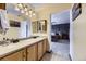 Bathroom featuring a double vanity, lighting, framed mirrors, and a view of bedroom at 17076 Foxton Dr, Parker, CO 80134