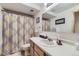 Bright bathroom showcasing a vanity with sink and mirror, toilet, and a shower with a patterned curtain at 17076 Foxton Dr, Parker, CO 80134