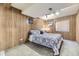 Charming bedroom featuring wood paneling, comfortable bed, and natural light from a window at 17076 Foxton Dr, Parker, CO 80134