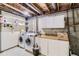 Functional laundry room featuring a washer, dryer, storage shelves, and exposed ceiling beams at 17076 Foxton Dr, Parker, CO 80134
