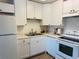 Well-lit kitchen boasts white cabinets, a stainless steel sink, and modern appliances at 755 S Alton Way # 12C, Denver, CO 80247