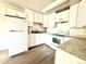 Bright kitchen featuring white cabinets, appliances, and updated countertops at 755 S Alton Way # 12C, Denver, CO 80247