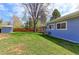 Spacious backyard featuring mature trees, lush green grass, a shed and a partially covered patio at 2561 S Carey Way, Denver, CO 80222