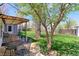 Backyard featuring a covered patio, lush lawn, mature trees, and a charming outdoor seating area at 2561 S Carey Way, Denver, CO 80222